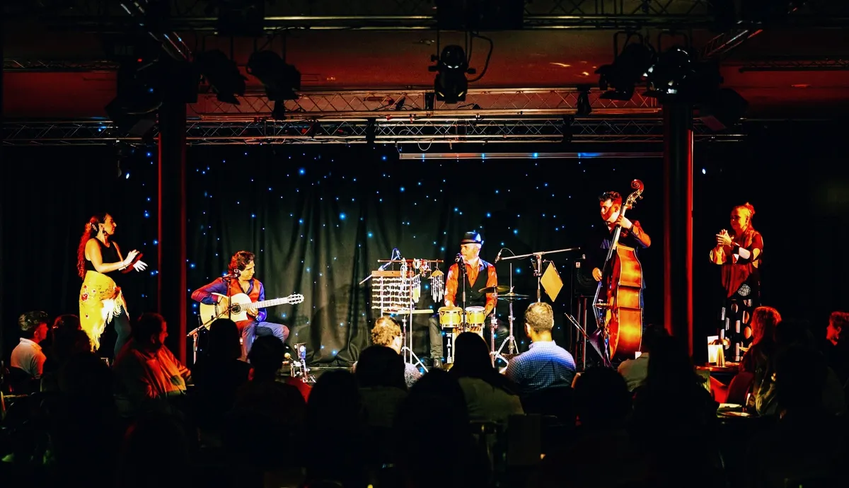 Ernesto Castillo on stage with his band and two flamenco dancers