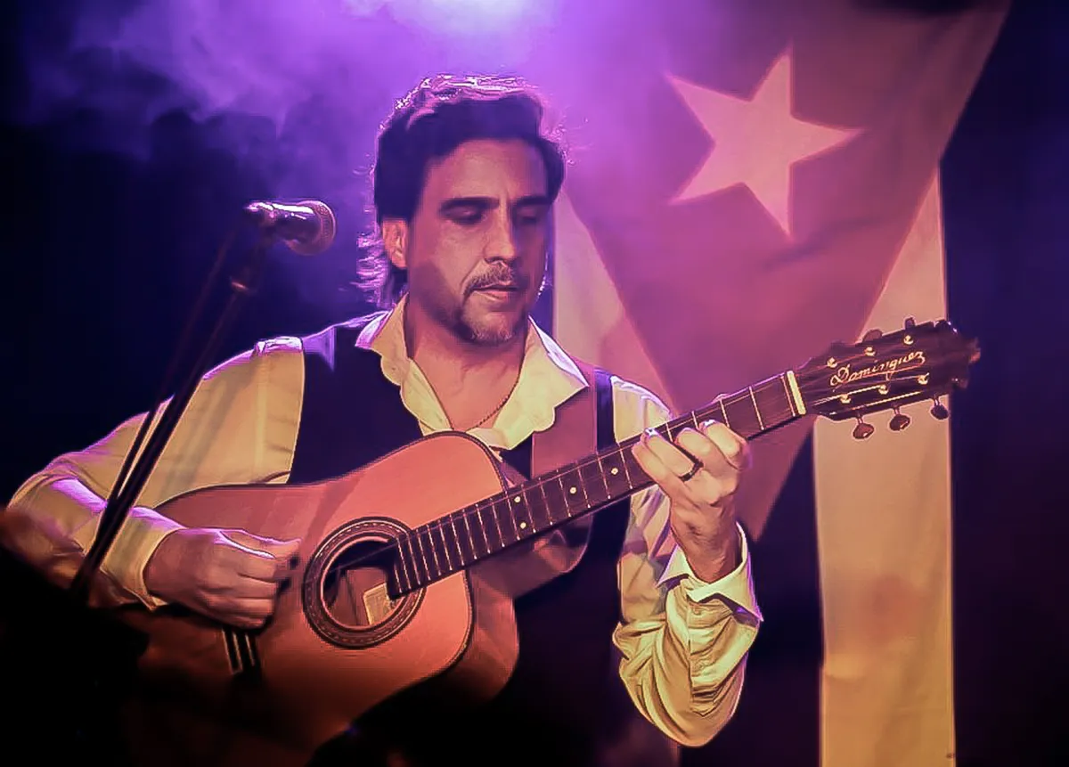 Ernesto Castillo at Fringe World Festival 2020 with the Cuban flag behind him