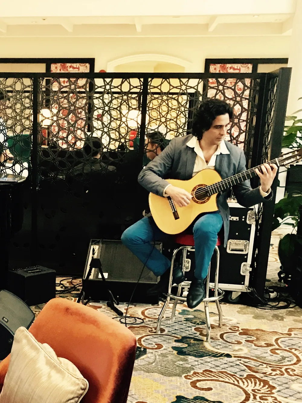Ernesto Castillo playing nylon-string guitar in the lobby of the InterContinental hotel
