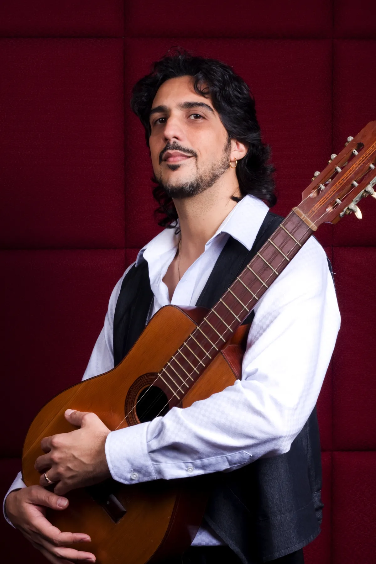 Portrait of Ernesto Castillo holding a nylon-string guitar