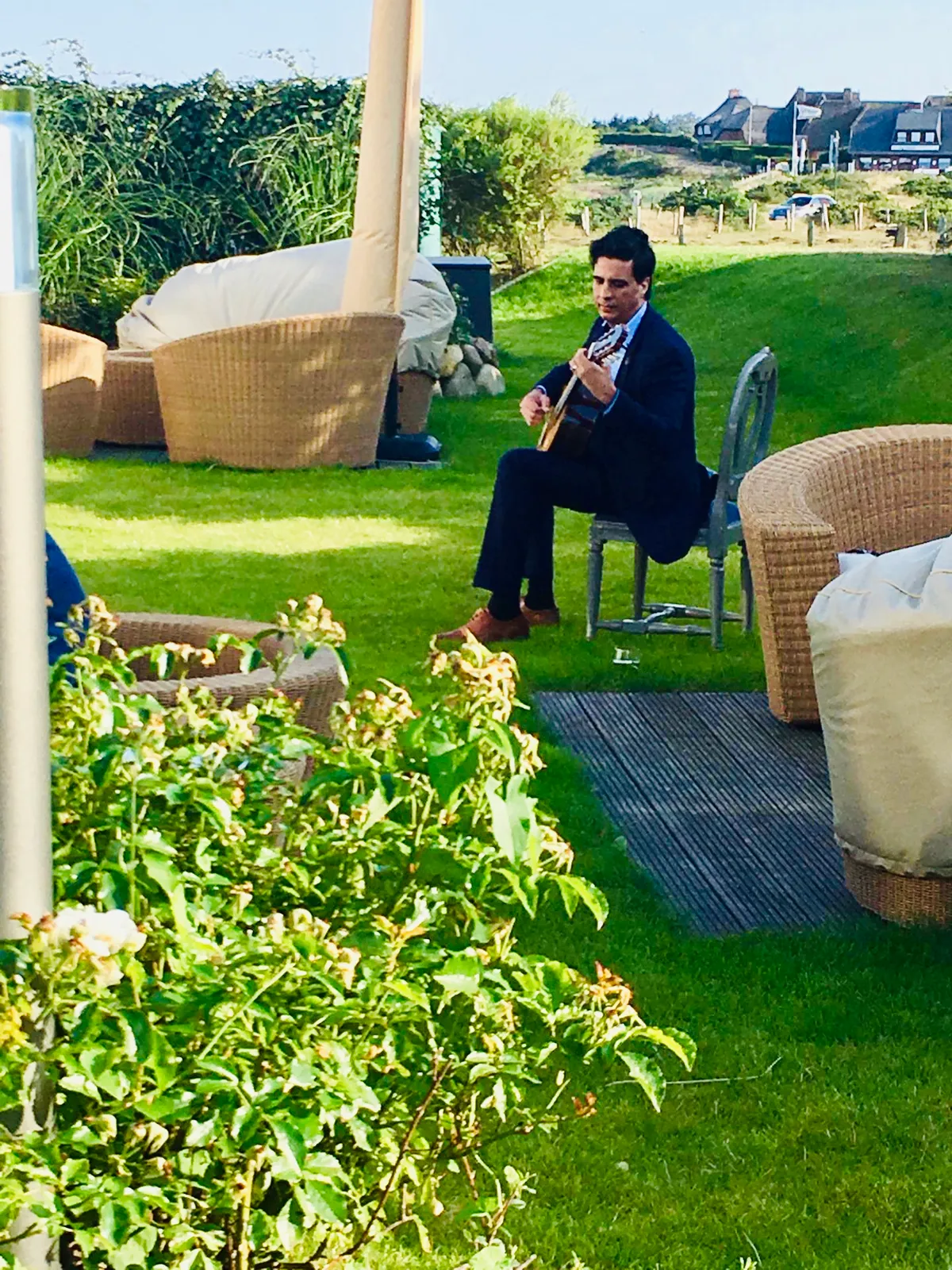 Ernesto Castillo playing guitar in a rooftop garden