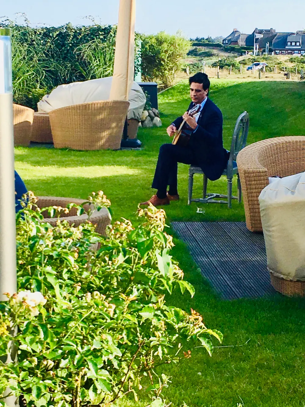 Ernesto Castillo playing guitar in a rooftop garden
